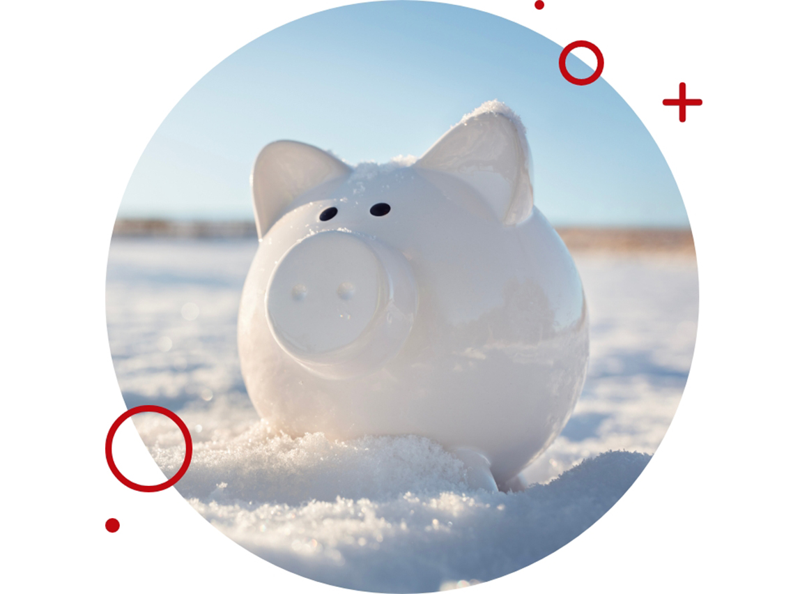 White piggy bank sitting in the snow on a sunny winter day, symbolizing savings or financial security.