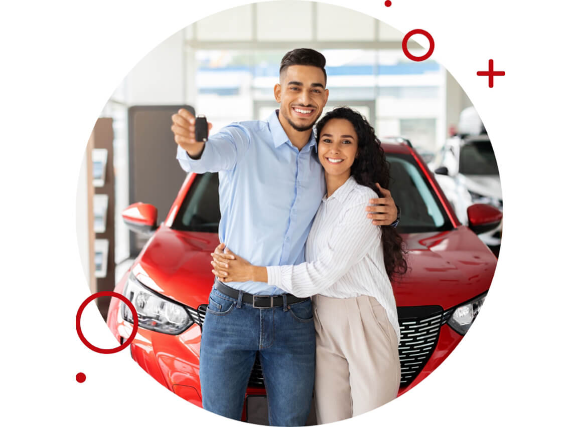 Happy couple posing in front of a new red car, with the man holding a car key.”